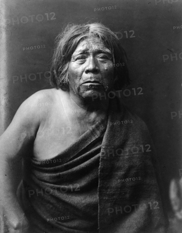 Mat Stams-Maricopa, half-length portrait, facing front, wrapped in blanket, c1907. Creator: Edward Sheriff Curtis.