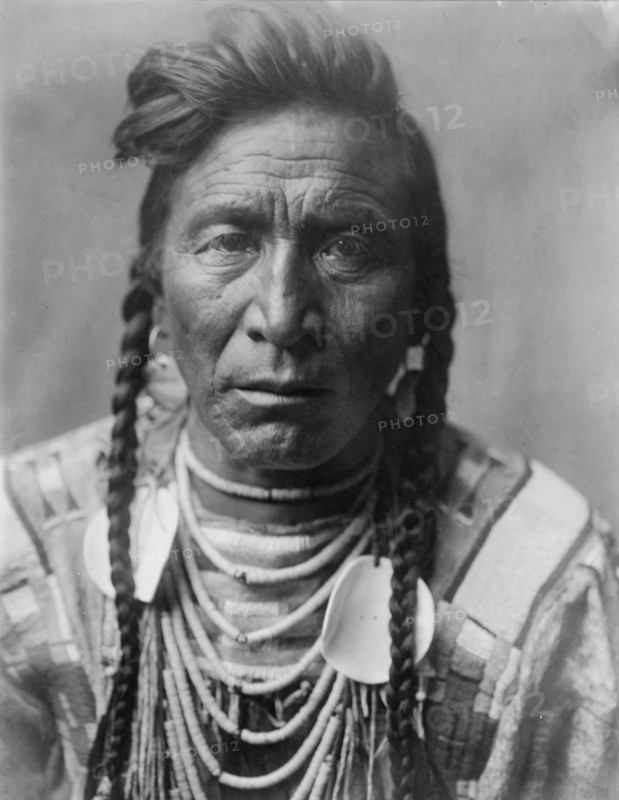 Strike On his Head, Crow Indian, Montana, head-and-shoulders portrait, facing front, loose..., c1908 Creator: Edward Sheriff Curtis.