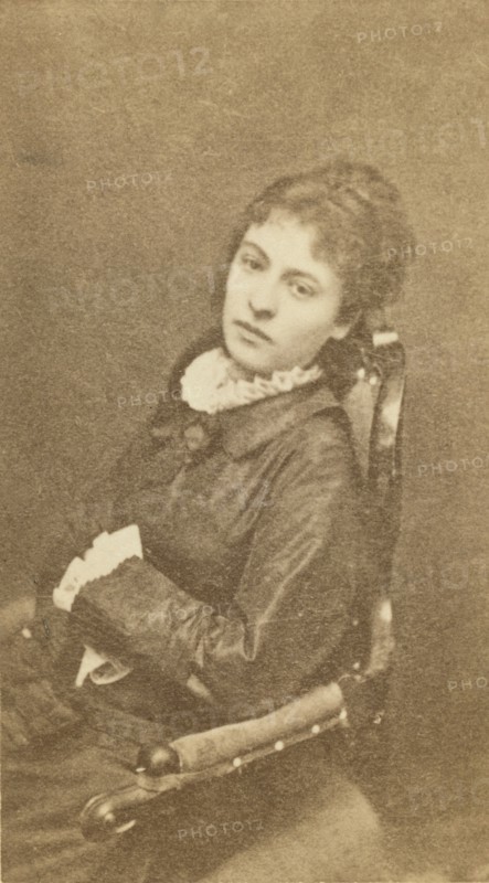 Three-quarter length portrait of woman, seated in chair, facing left, between 1880 and 1886. Creator: Unknown.