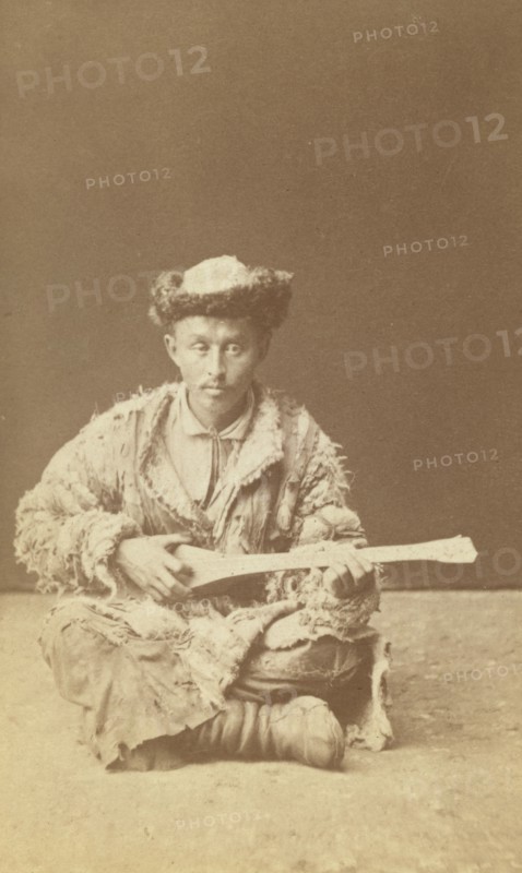 Kazakh man, a musician with a dombra, seated, between 1870 and 1886. Creator: Unknown.