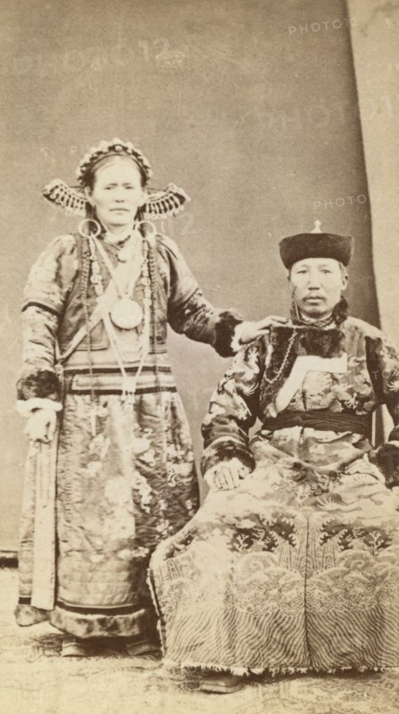Full-length portrait of wealthy Buriat man and his wife, facing front, between 1870 and 1886. Creator: Unknown.
