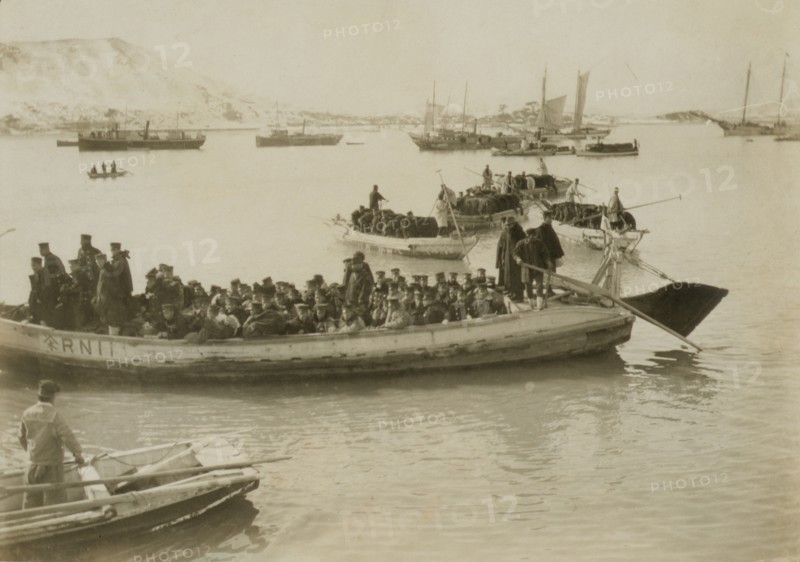 String of pontoons in tow of stream launch, approaching landing stage, Chemulpo, c1904. Creator: Robert Lee Dunn.