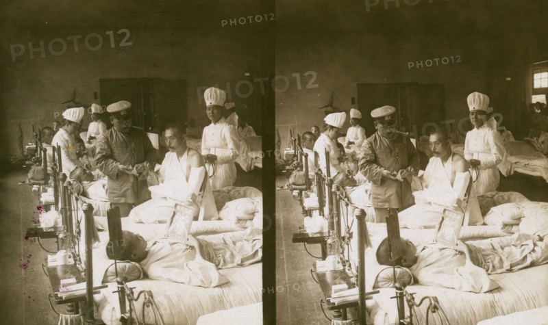 Nurses and a doctor attending wounded soldiers on a hospital ward, c1905. Creator: Underwood & Underwood.