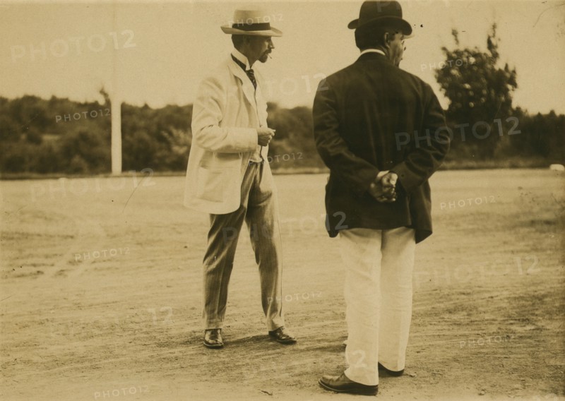 Two men, probably journalists, standing on a field, 1905. Creator: Unknown.