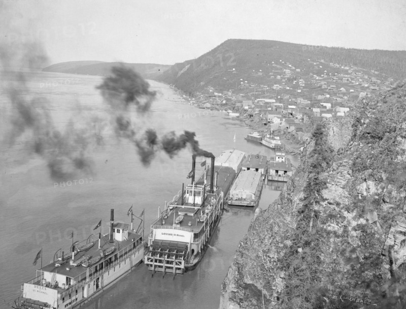 Riverboats distant view of town, between c1900 and 1923. Creator: Unknown.