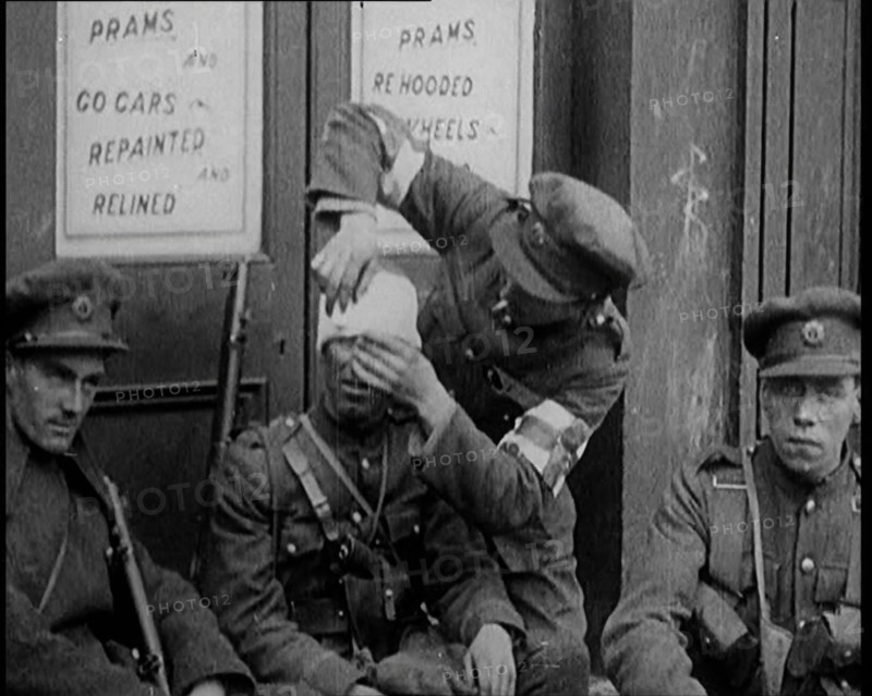 Irish Soldiers Sitting in the Street and Tending to Their Injuries from Fighting in Dublin, 1922. Creator: British Pathe Ltd.