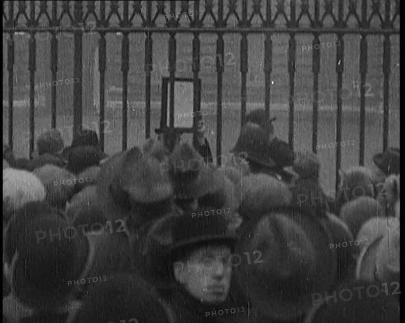 A Male Civilian Holding up a Bulletin from the Doctor to Crowds Gathering Outside..., 1929. Creator: British Pathe Ltd.