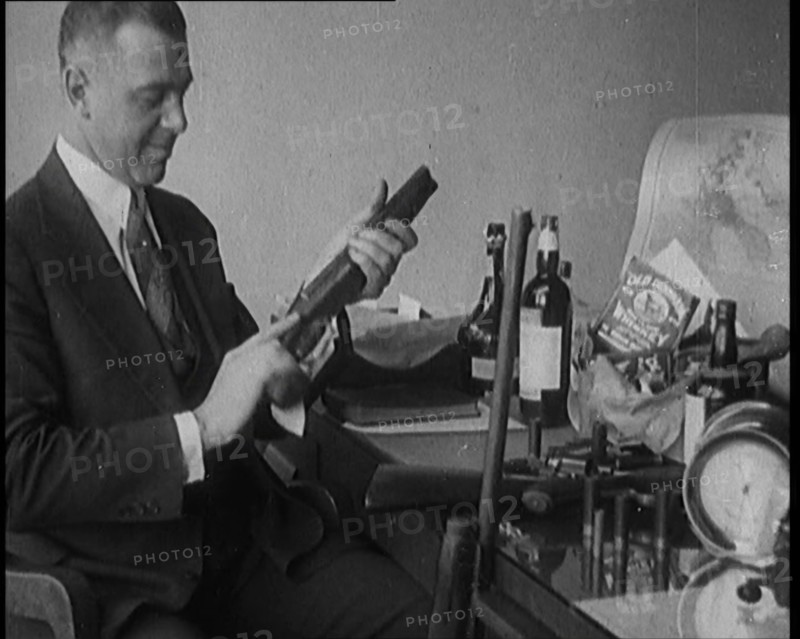 Male Detective Showing off Smugglers' Captured Guns, 1929.  Creator: British Pathe Ltd.