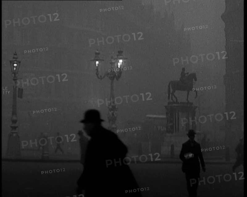 Male Civilians Walking Through the Foggy Streets of London, 1929. Creator: British Pathe Ltd.