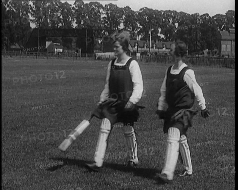 Two Female Civilians Wearing Gymslips and Batting Pads Holding Cricket Bats in a Playing Field, 1920 Creator: British Pathe Ltd.