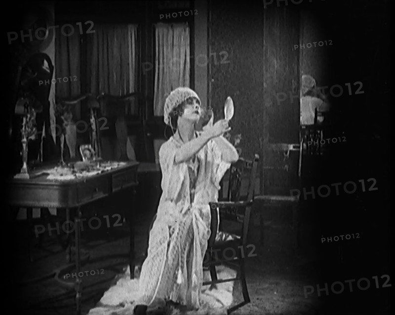 Female Civilian Seating in Front of a Dressing Table Wearing a Nightgown and Boudoir Cap..., 1920. Creator: British Pathe Ltd.
