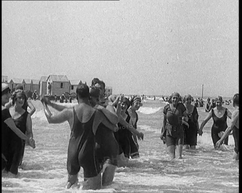 Civilians Wearing Swimsuits Enjoying a Sunny Day Dancing at a Very Crowded Beach, 1920. Creator: British Pathe Ltd.