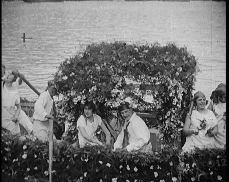 Civilians on a Boat Heavily Decorated with Flowers, 1920. Creator: British Pathe Ltd.