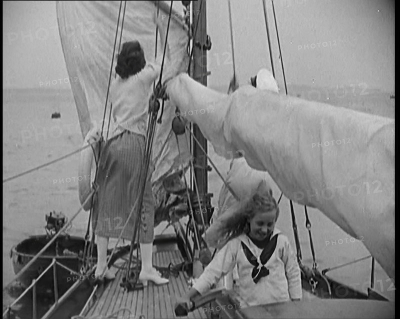 Female Civilians Wearing Summer Outfits and a Captain's Hat Onboard of a Boat Hoisting up a..., 1920 Creator: British Pathe Ltd.