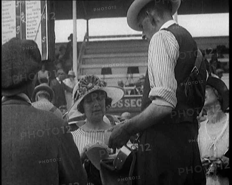 A Female Civilian Placing a Bet with a Bookie in a Horse Racing Event, 1920. Creator: British Pathe Ltd.