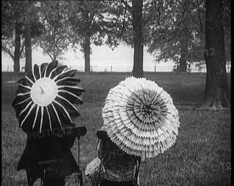 Female Civilians Holding Ornate Parasols in a Park, 1920. Creator: British Pathe Ltd.