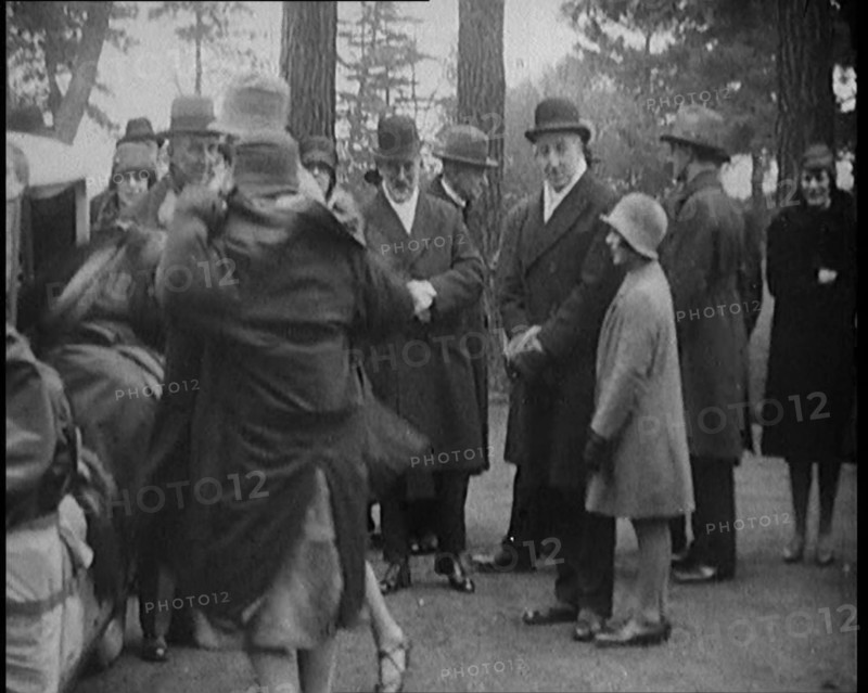 Female Civilian Helping Another Female Civilian to Put on a Coat in Front of a Car and a..., 1920. Creator: British Pathe Ltd.