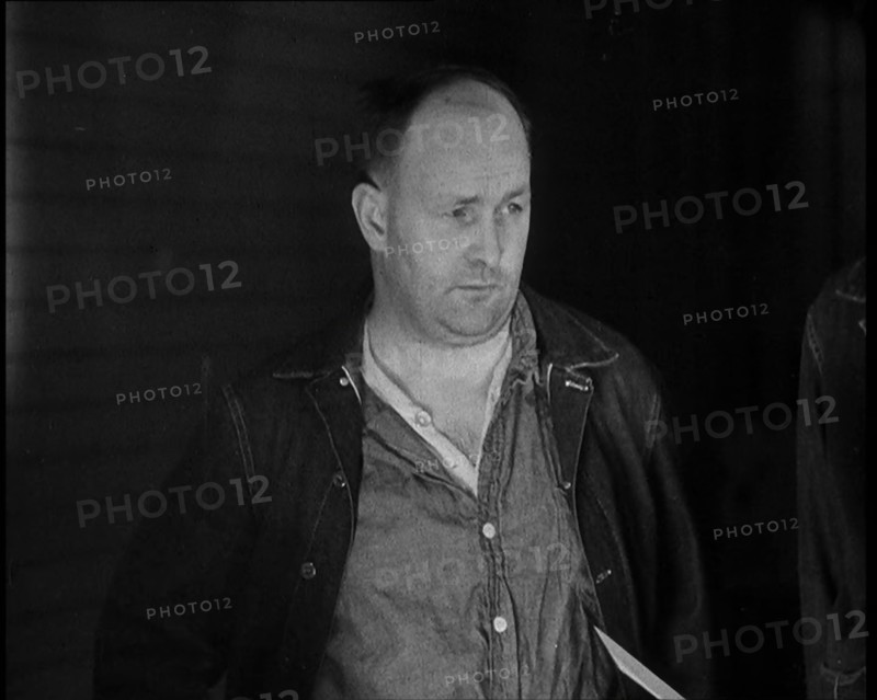 A group of Male Americans Civilians Wearing Prisoners Outfits Being Escorted Into a Room..., 1930. Creator: British Pathe Ltd.