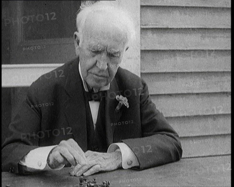 Thomas Edison Sitting at an Outside Desk and Operating a Morse Code Sender, 1921. Creator: British Pathe Ltd.