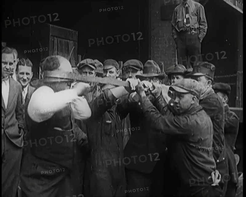 A Male Stuntman Bending Iron Bars Around His Head, 1926. Creator: British Pathe Ltd.