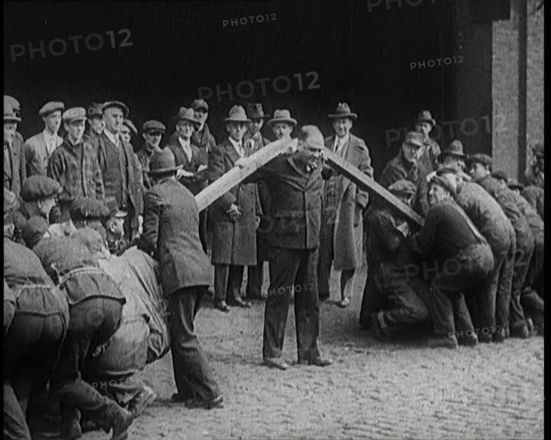 A Male Stuntman Bending Girders Over His Shoulders, 1926. Creator: British Pathe Ltd.