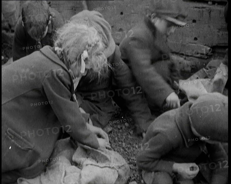 Close up of Male and Female Children Picking Through Small Heaps of Coal on the Ground, 1924. Creator: British Pathe Ltd.