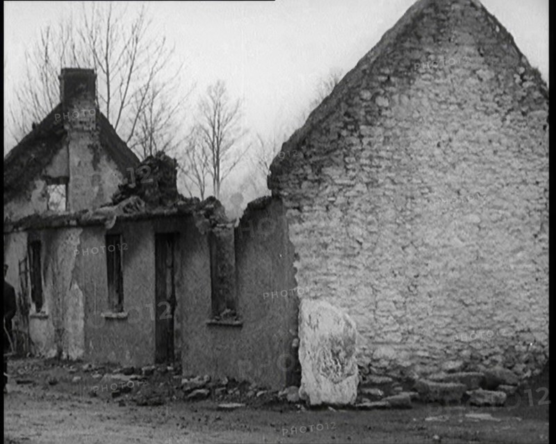 A Man Standing Outside a Burnt Out Cottage in Ireland, Holding a Bicycle, 1921. Creator: British Pathe Ltd.