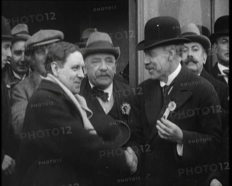 British Man Exiting a Building and Shaking Hands as Part of a by Election Campaign, 1921. Creator: British Pathe Ltd.
