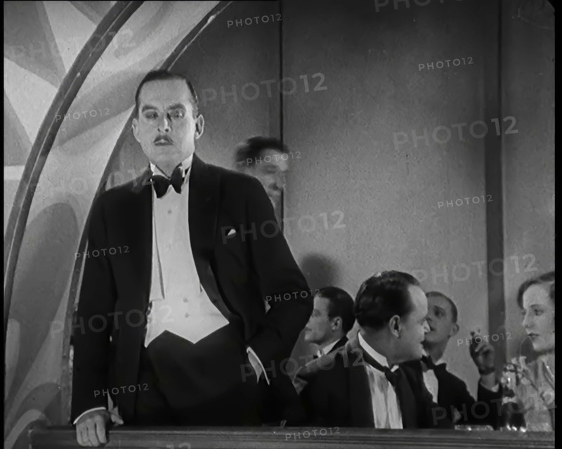 Scene from the Film 'Champagne': Male Actor Standing on a Balcony Overlooking the Nightclub...,1920s Creator: British Pathe Ltd.