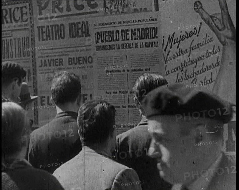 Residents of Madrid Looking at Government Posters on a Wall, 1937. Creator: British Pathe Ltd.