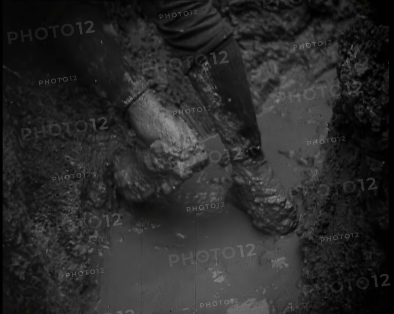 The Legs and Boots of a Male French Soldiers as He is Standing in a Water-Logged Muddy Trench, 1939. Creator: British Pathe Ltd.