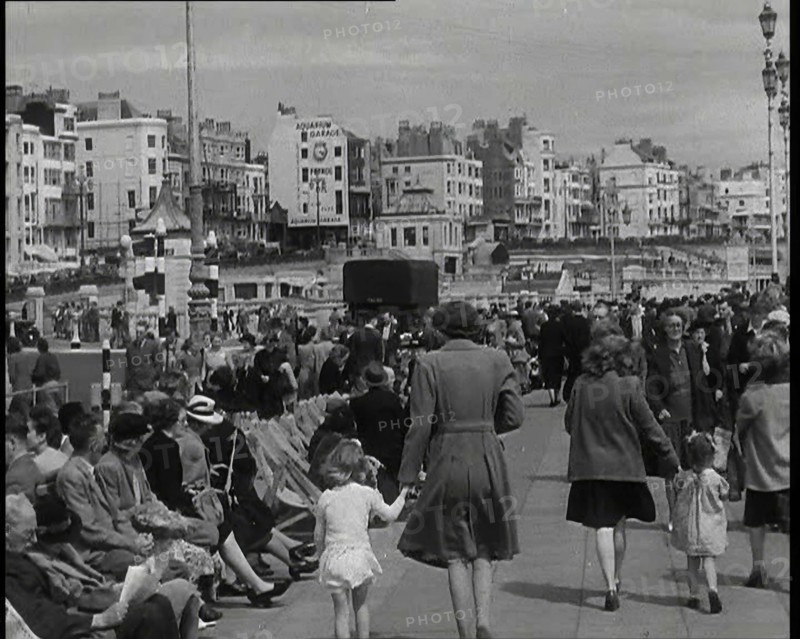 British Holidaymakers Walking Along the Promenade or Sitting on Deckchairs at Brighton..., 1938. Creator: British Pathe Ltd.