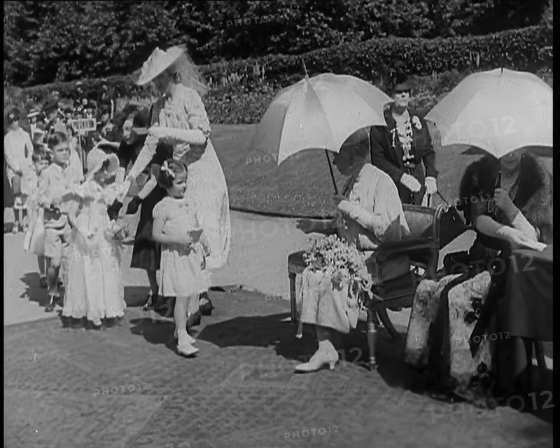 A Young British Girl Approaching the Chair of Queen Mary of Teck With a Purse in Her Hand..., 1939. Creator: British Pathe Ltd.