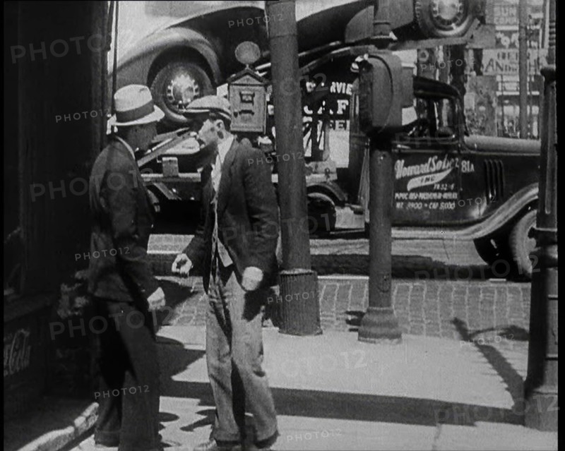 Male Civilian Stopping People On the Street Perhaps Begging or Perhaps Asking For a Job, 1932. Creator: British Pathe Ltd.