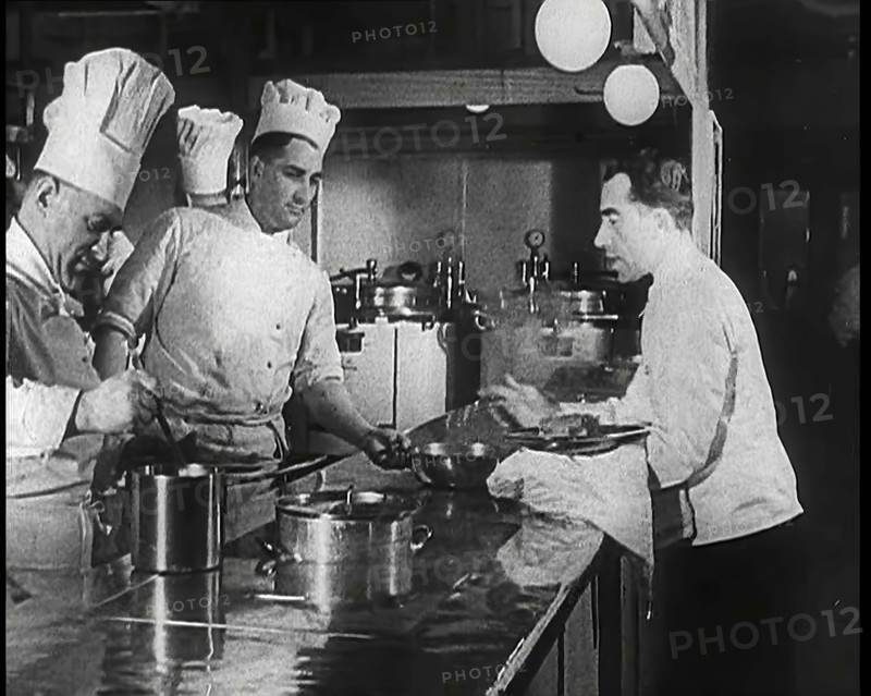 A Galley With Kitchen Staff Cooking and Waiters With Dishes on Board the 'Strength Through..., 1939. Creator: British Pathe Ltd.