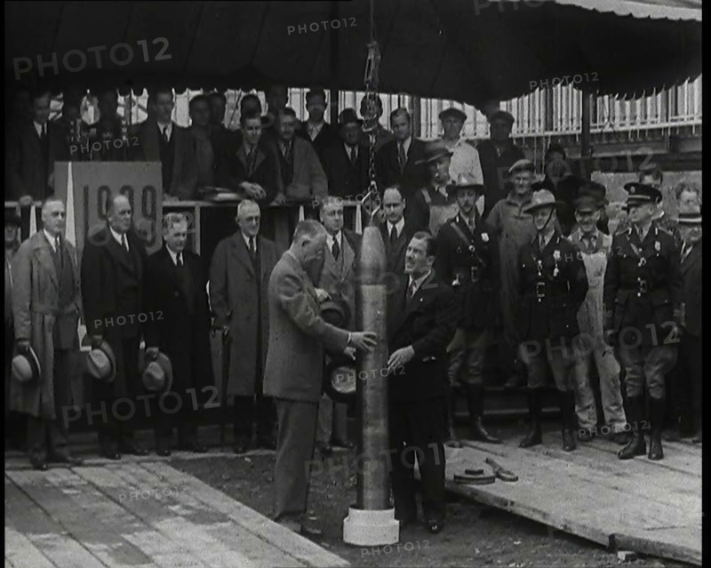 Two British Men Guiding a Time Capsule Being Lowered in the Ground With Various Civilians..., 1938. Creator: British Pathe Ltd.