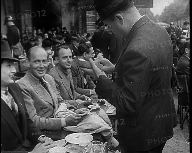 French Police Checking People's Papers Outside a Cafe in Paris, 1940. Creator: British Pathe Ltd.