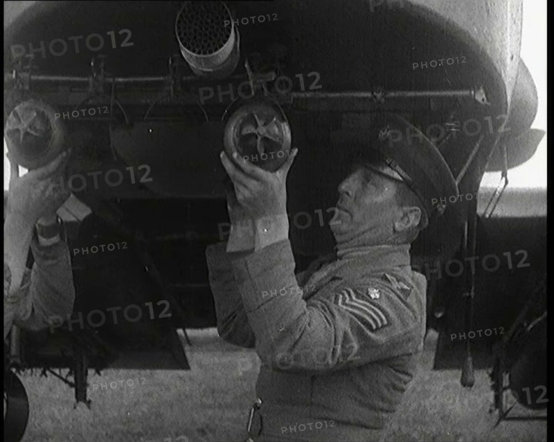 Male British Officers Mounting Bombs Into a Fighter Plane, 1920s. Creator: British Pathe Ltd.