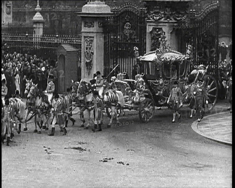 The Royal Coach, Horses, and Procession Filing Out of the Gates at the Front of Buckingham..., 1937. Creator: British Pathe Ltd.