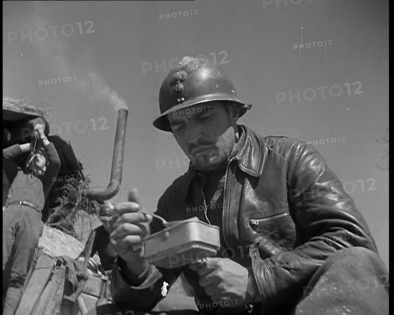 French Soldiers Eating a Meal in a Dug Out, 1940. Creator: British Pathe Ltd.