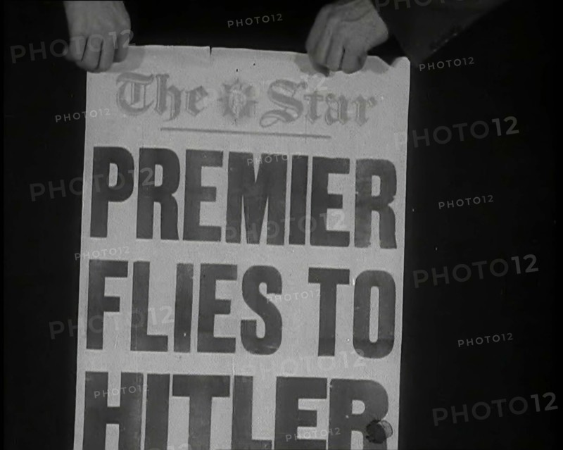Two Hands Holding the Star Newspaper Headline 'PREMIER FLIES TO HITLER', 1938. Creator: British Pathe Ltd.