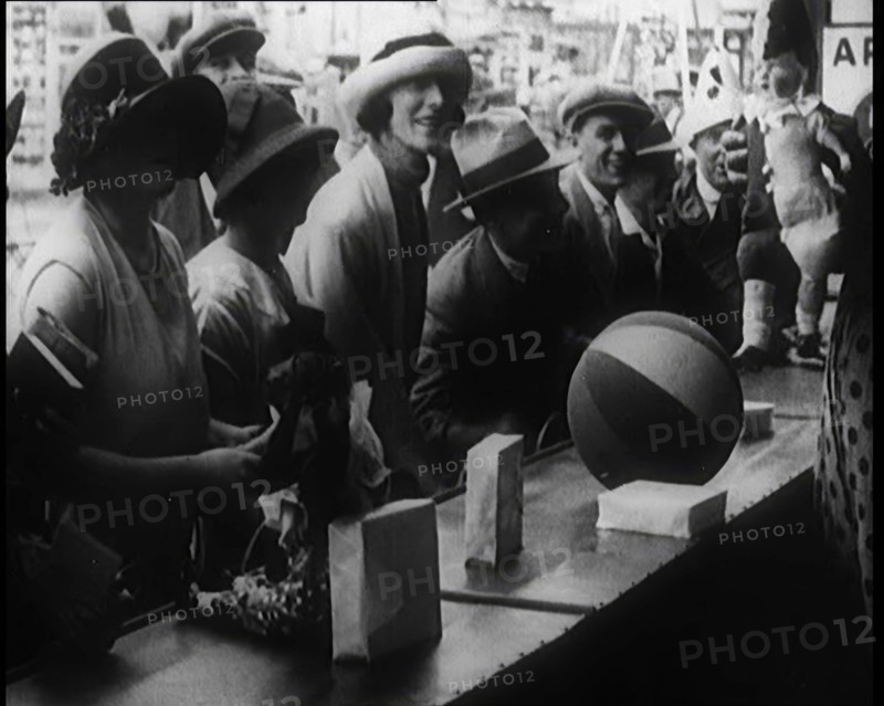A Crowd of People Playing a Game Where They Have to Pop a Balloon By Turning a Handle, 1924. Creator: British Pathe Ltd.