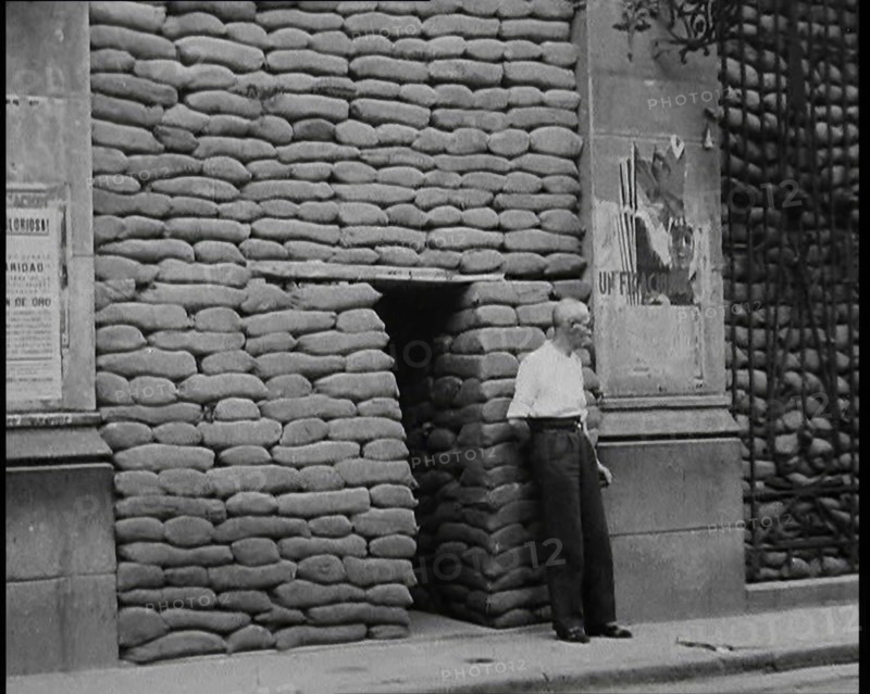 A Man Standing Outside the Frontage of a Building Obscured By Sandbags Next To an..., 1937. Creator: British Pathe Ltd.