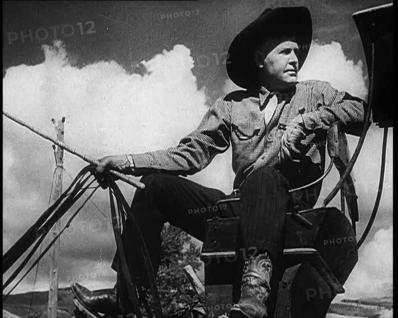 Male Civilian With a Cowboy Hat Sitting On a Coach Waiting For Passengers, 1932. Creator: British Pathe Ltd.