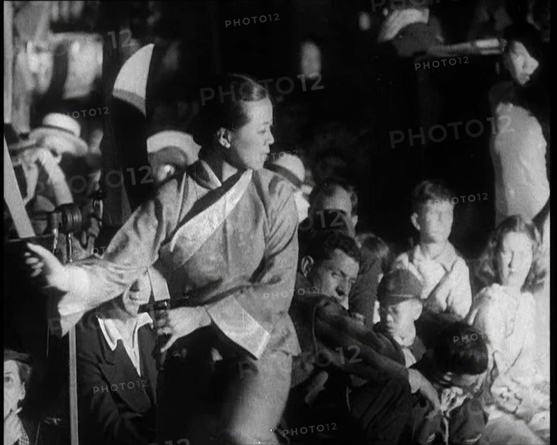 A Female Civilian in a Traditional Robe Dancing With Sabres As People Watch Her Performanc..., 1932. Creator: British Pathe Ltd.