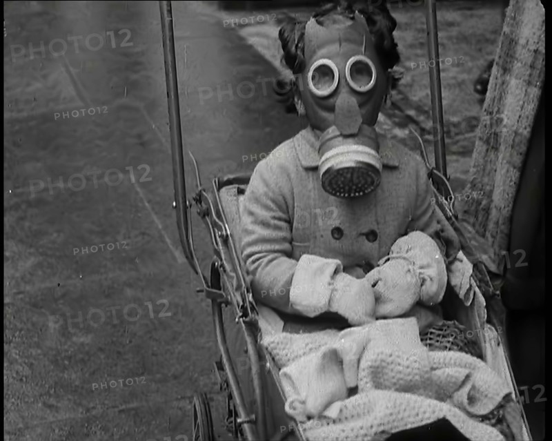 A Young Child in a Pram Wearing a Gas Mask, 1939. Creator: British Pathe Ltd.