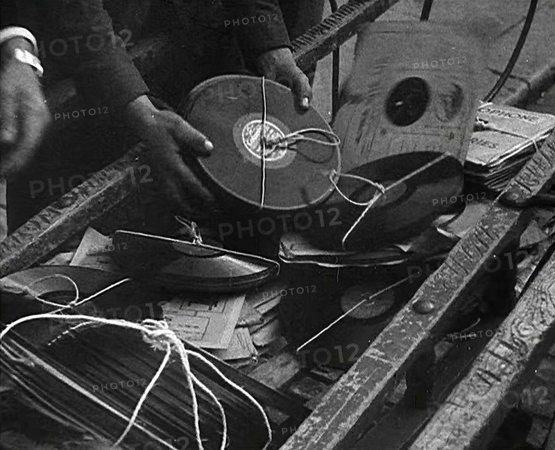A Man Dumping Old gramophone records to Use for War Materials, 1942. Creator: British Pathe Ltd.