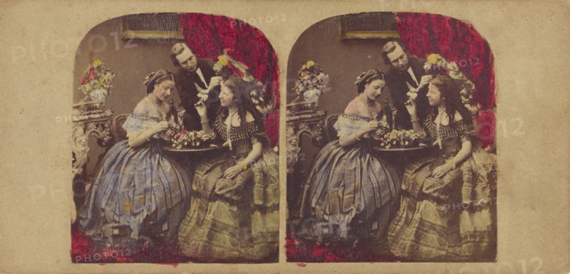 Parlor scene: woman seated at table, man standing at center, about 1860. Creator: Edward Anthony.