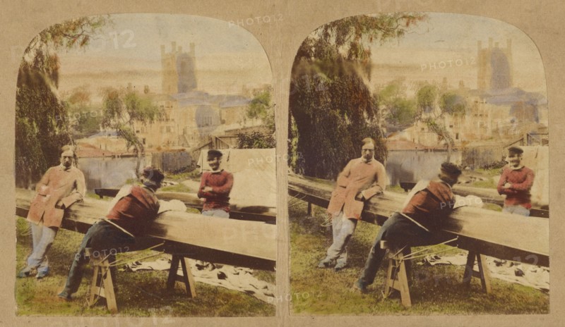 Three men at a table outside, castle in background, 1857-1862. Creator: Roger Fenton.