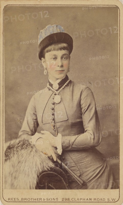 Unidentified woman standing, holding a fan, 1879. Creator: David Rees & Brother & Son.